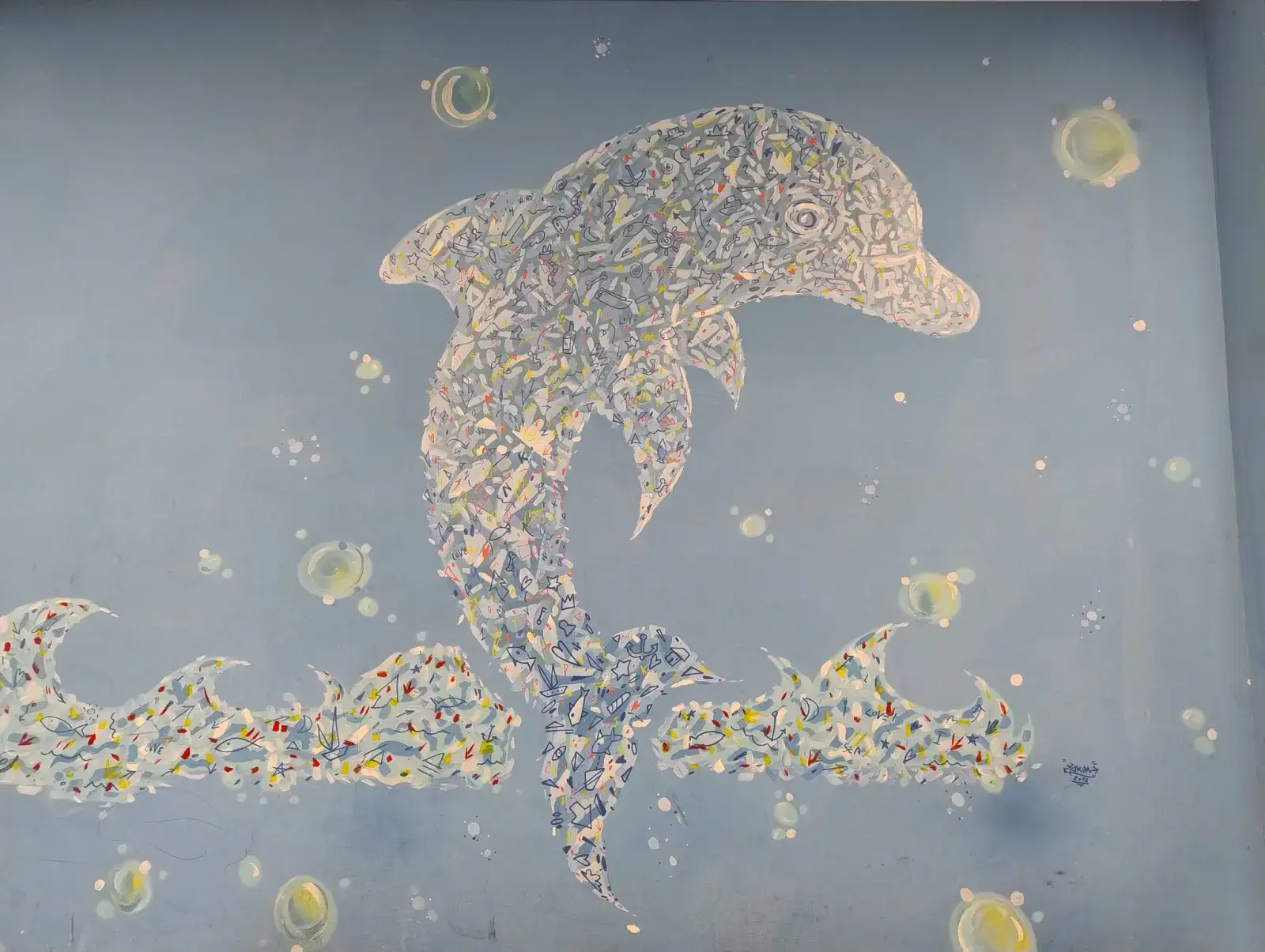 Murale del delfino a mosaico sulla parete azzurra della lavanderia